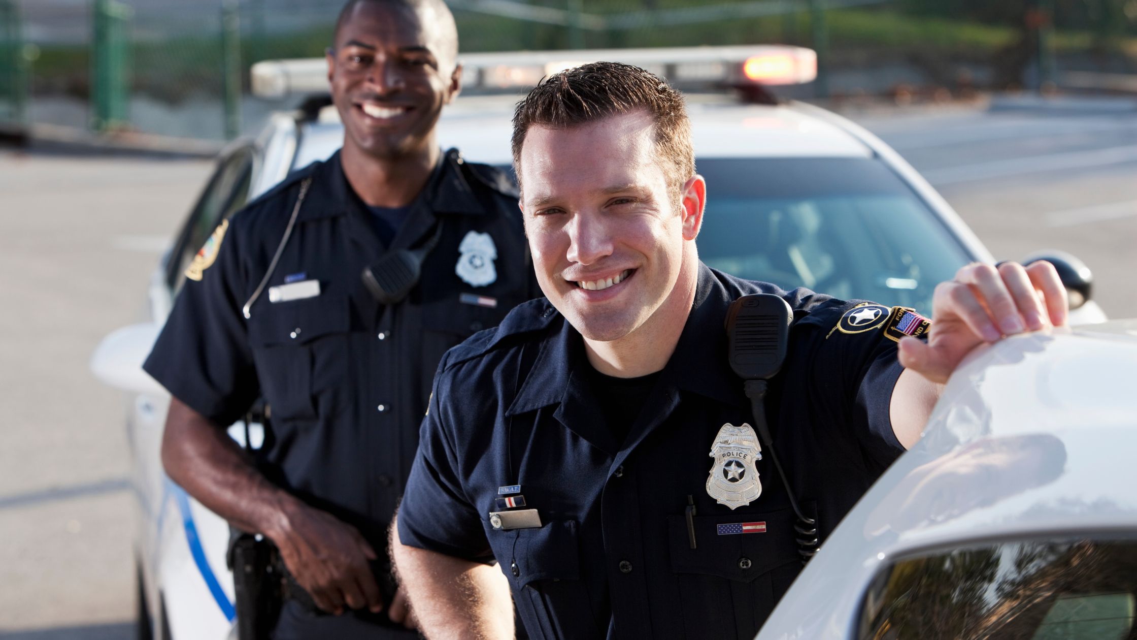Two police officers smiling together after de-escalation training